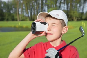 A boy wearing shirt using a golf rangefinder